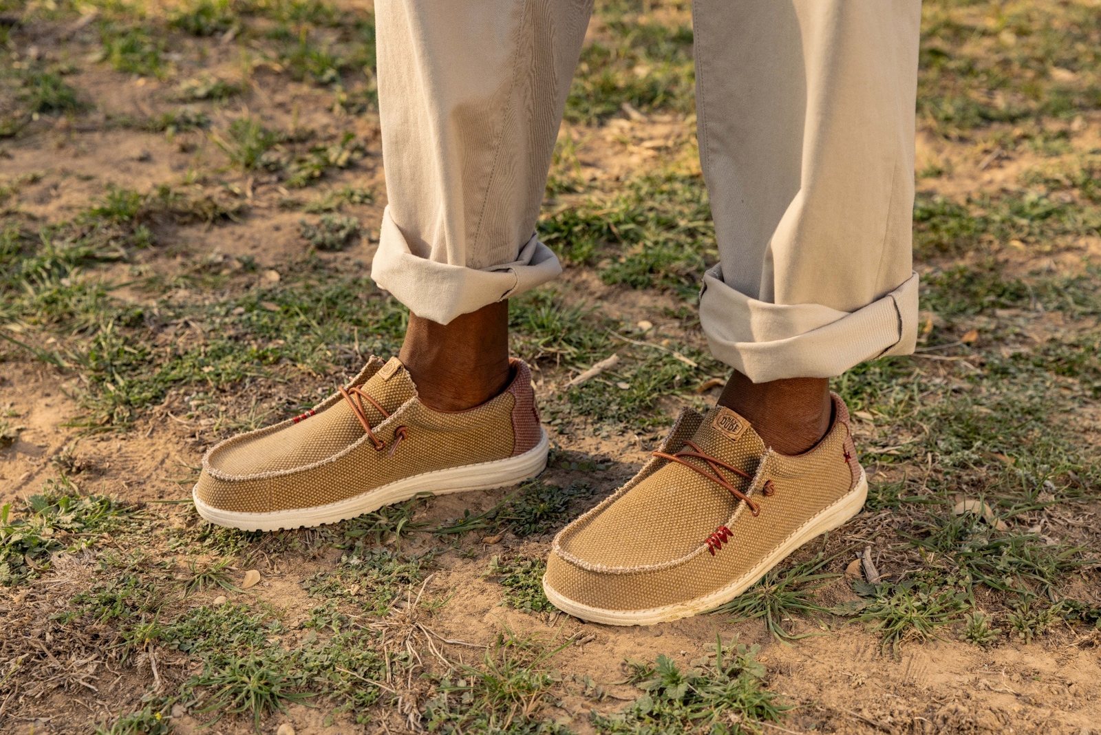 Two pairs of HEYDUDE braided slip-ons on grass